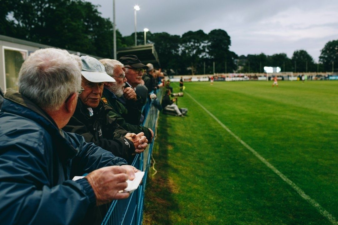 Åskådare följer en fotbollsmatch från sidlinjen