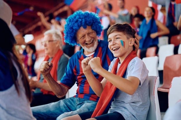 Pojke och vuxen supporter jublar tillsammans på en idrottsläktare